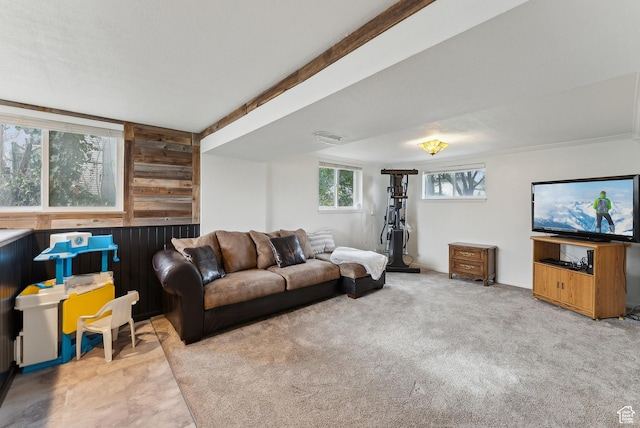 living room featuring visible vents, wooden walls, and carpet floors