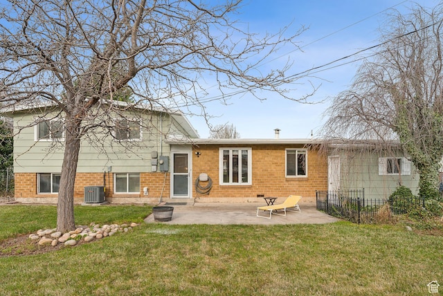 back of house with fence, brick siding, a patio, central AC, and a yard