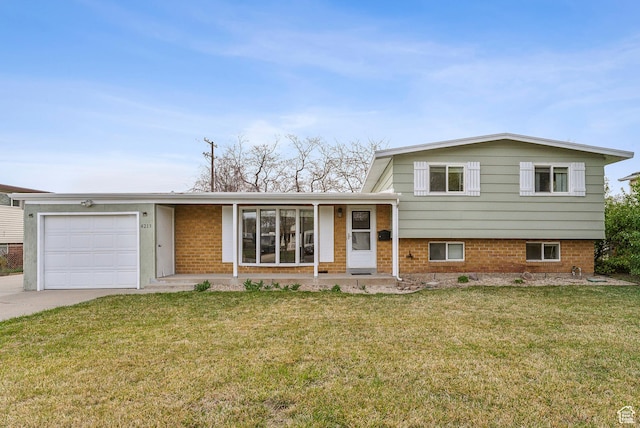 split level home with driveway, a front yard, a garage, and brick siding