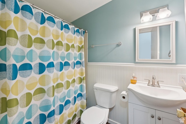 full bath featuring a wainscoted wall, vanity, toilet, and a shower with shower curtain