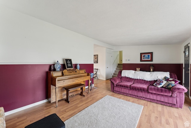 living room with baseboards, stairs, and wood finished floors