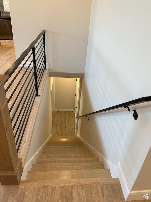 staircase featuring baseboards and wood finished floors