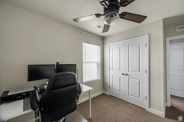 office space with carpet flooring, baseboards, ceiling fan, and visible vents