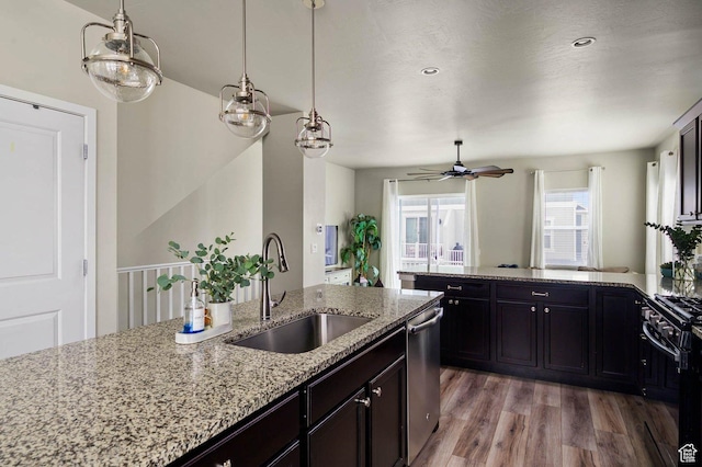 kitchen with a sink, dishwasher, a peninsula, light wood-type flooring, and black range with gas cooktop
