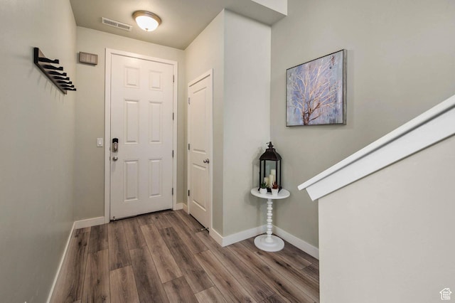 entryway featuring baseboards, visible vents, and wood finished floors