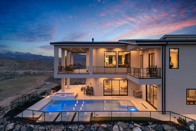599 W 170 S, La Verkin, UT 84745 - back of property at dusk featuring stucco siding, fence, a patio, a balcony, and a pool with connected hot tub