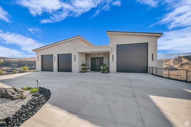 599 W 170 S, La Verkin, UT 84745 - contemporary home with concrete driveway, stucco siding, an attached garage, stone siding, and a mountain view