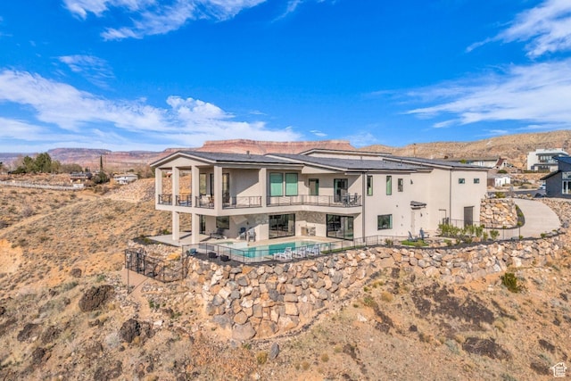 599 W 170 S, La Verkin, UT 84745 - rear view of house with stucco siding, a patio, a balcony, a mountain view, and roof mounted solar panels