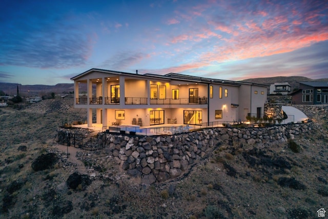 599 W 170 S, La Verkin, UT 84745 - back of property at dusk featuring an outdoor pool, a balcony, stucco siding, and a patio