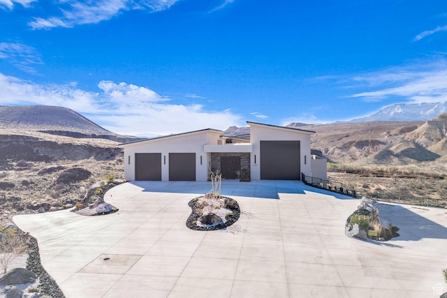 599 W 170 S, La Verkin, UT 84745 - view of front of home with stone siding, driveway, an attached garage, stucco siding, and a mountain view