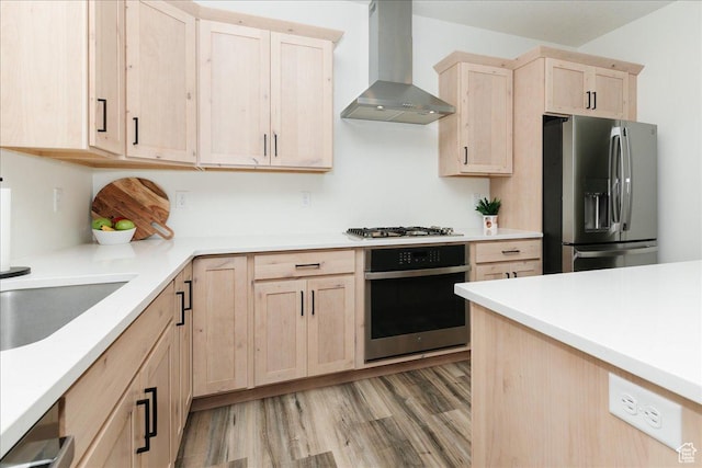602 W 20 N, Hyrum, UT 84319 - kitchen with light countertops, light wood-style flooring, light brown cabinets, appliances with stainless steel finishes, and wall chimney exhaust hood