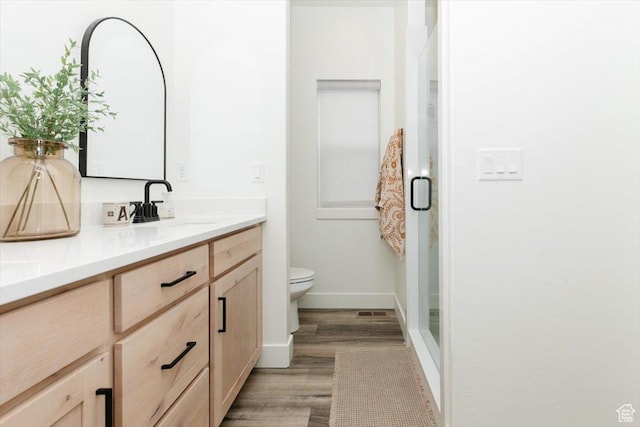 602 W 20 N, Hyrum, UT 84319 - full bathroom featuring a stall shower, toilet, vanity, wood finished floors, and baseboards