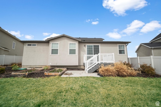 13099 S Twisted Oak Dr, Herriman, UT 84096 - rear view of property with a lawn, fence, and a vegetable garden