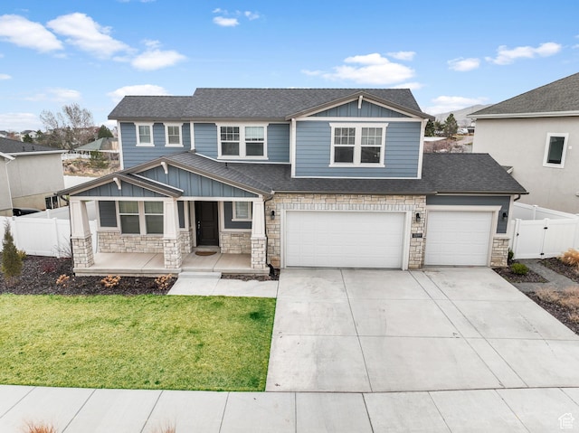 13099 S Twisted Oak Dr, Herriman, UT 84096 - view of front of house featuring a front yard, stone siding, concrete driveway, fence, and a porch