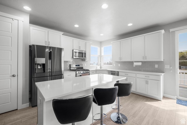 13099 S Twisted Oak Dr, Herriman, UT 84096 - kitchen with white cabinetry, a sink, stainless steel appliances, and light wood-type flooring
