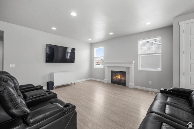 13099 S Twisted Oak Dr, Herriman, UT 84096 - living area featuring baseboards, a glass covered fireplace, recessed lighting, and light wood-type flooring