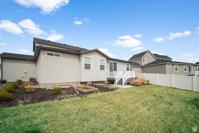 13099 S Twisted Oak Dr, Herriman, UT 84096 - back of house featuring fence, central air condition unit, stucco siding, a lawn, and a vegetable garden