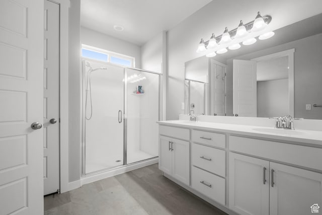 13099 S Twisted Oak Dr, Herriman, UT 84096 - bathroom with double vanity, a sink, a stall shower, and wood finished floors
