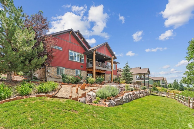 5265 N Laurelwood St N, Heber City, UT 84032 - back of house featuring fence, stone siding, a lawn, and a balcony