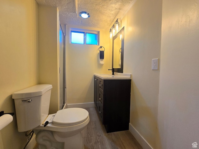 2084 Robins Ave, Ogden, UT 84401 - bathroom featuring toilet, wood finished floors, vanity, an enclosed shower, and baseboards
