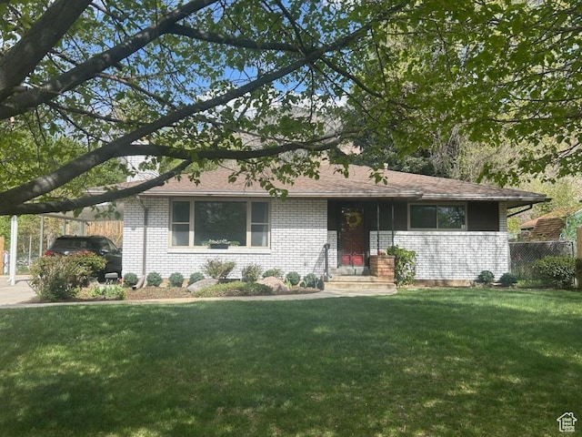 ranch-style house featuring a front yard and brick siding