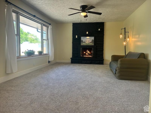 2084 Robins Ave, Ogden, UT 84401 - living room featuring a textured ceiling, a ceiling fan, carpet floors, a large fireplace, and baseboards