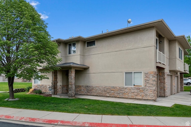 6613 W Ivy Gable Dr, West Jordan, UT 84081 - view of front of house with stone siding, stucco siding, a front yard, and a garage