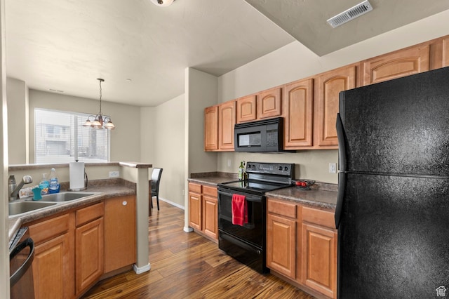 6613 W Ivy Gable Dr, West Jordan, UT 84081 - kitchen with black appliances, a sink, dark wood-type flooring, dark countertops, and a chandelier