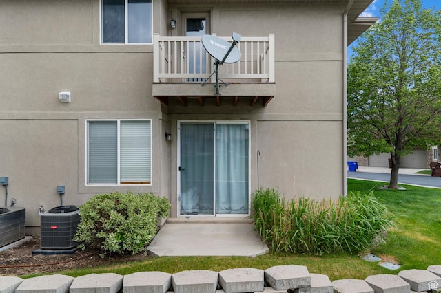 6613 W Ivy Gable Dr, West Jordan, UT 84081 - view of exterior entry with a balcony, central air condition unit, and stucco siding