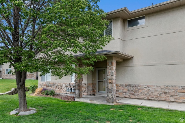 6613 W Ivy Gable Dr, West Jordan, UT 84081 - entrance to property with stone siding, a lawn, and stucco siding