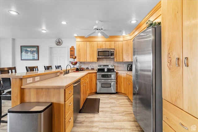 170 E 400 N, Mount Pleasant, UT 84647 - kitchen with a peninsula, a kitchen bar, tasteful backsplash, appliances with stainless steel finishes, and a sink