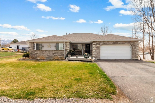 single story home with fence, brick siding, aphalt driveway, a front lawn, and a garage