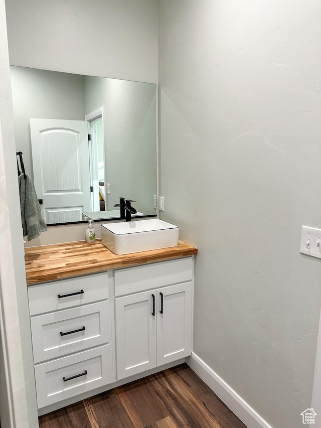 690 N Main St, Antimony, UT 84712 - bathroom featuring baseboards, wood finished floors, and vanity