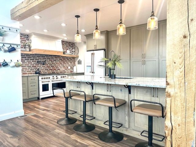 690 N Main St, Antimony, UT 84712 - kitchen featuring custom exhaust hood, light stone countertops, dark wood-type flooring, gray cabinetry, and high quality appliances