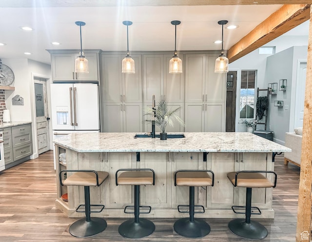 690 N Main St, Antimony, UT 84712 - kitchen featuring gray cabinetry, light stone countertops, wood finished floors, and white fridge with ice dispenser