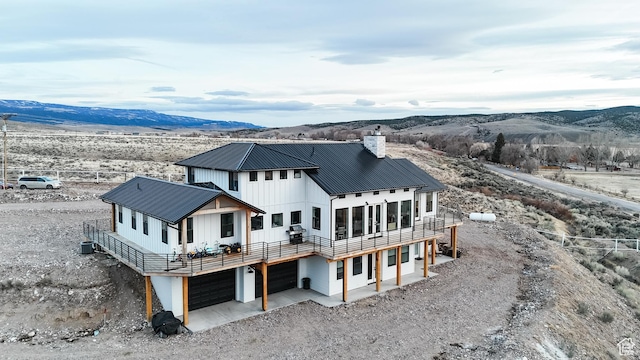 690 N Main St, Antimony, UT 84712 - rear view of property with dirt driveway, metal roof, a chimney, and a garage