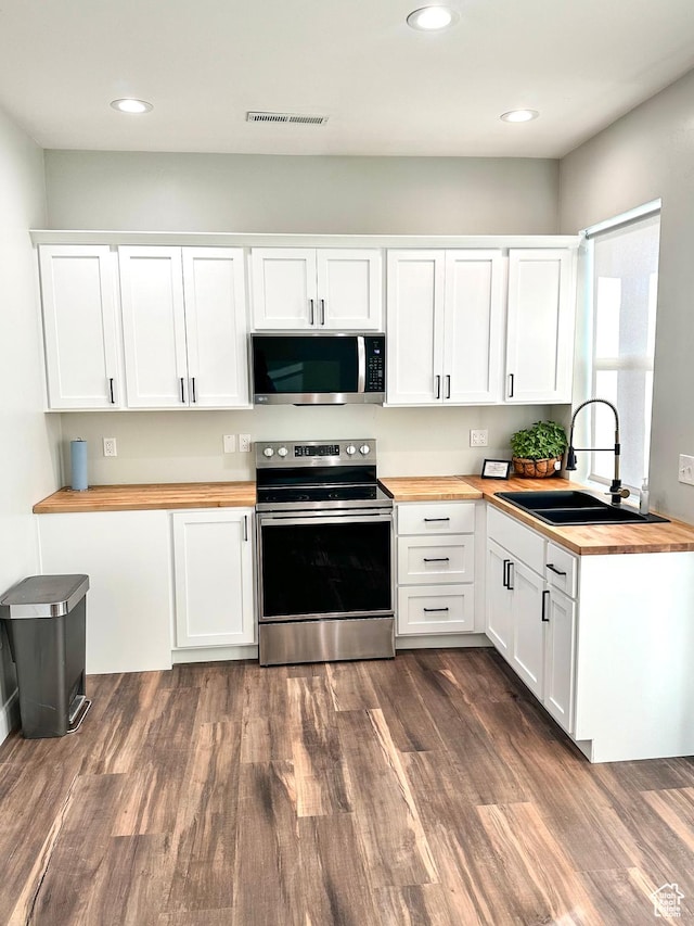 690 N Main St, Antimony, UT 84712 - kitchen with a sink, butcher block countertops, dark wood-style floors, stainless steel appliances, and visible vents