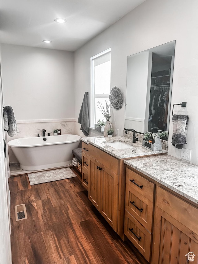 690 N Main St, Antimony, UT 84712 - full bath featuring vanity, recessed lighting, a soaking tub, visible vents, and wood finished floors