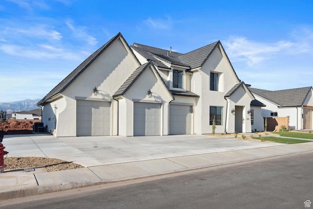 3087 E 2220 S, St George, UT 84790 - view of front facade featuring stucco siding, concrete driveway, central AC unit, a mountain view, and a garage