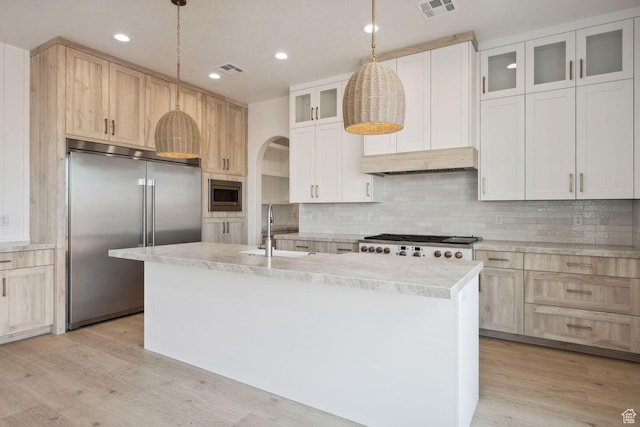 3087 E 2220 S, St George, UT 84790 - kitchen with built in appliances, a sink, light countertops, light wood finished floors, and tasteful backsplash