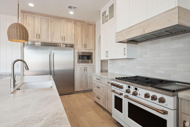 3087 E 2220 S, St George, UT 84790 - kitchen with built in appliances, custom exhaust hood, a sink, light brown cabinets, and light wood-type flooring