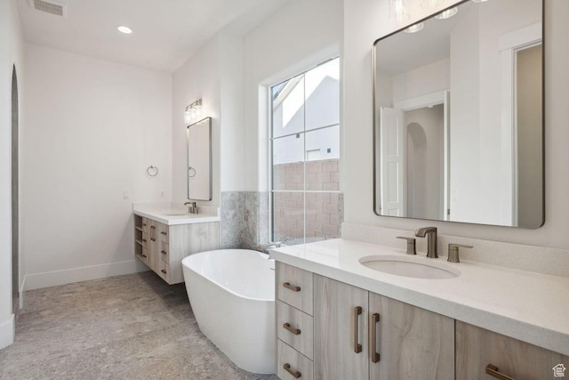 3087 E 2220 S, St George, UT 84790 - bathroom featuring two vanities, a freestanding bath, baseboards, and recessed lighting