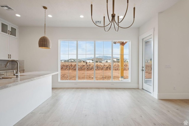 3087 E 2220 S, St George, UT 84790 - unfurnished dining area with a sink, light wood finished floors, recessed lighting, a chandelier, and baseboards