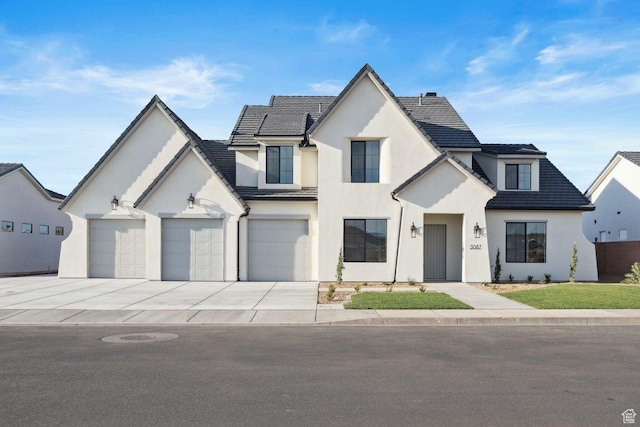view of front of home with stucco siding, a tile roof, a garage, and concrete driveway