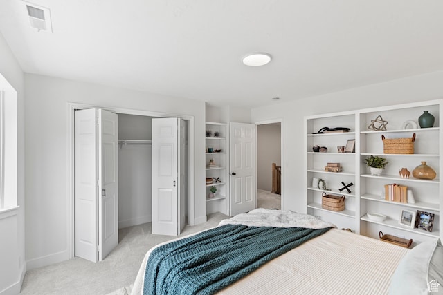 bedroom featuring baseboards, a closet, visible vents, and light colored carpet