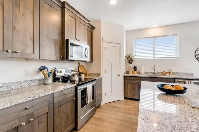 2233 S Beachcomber Ln, Garden City, UT 84028 - kitchen with light wood-style flooring, light stone countertops, stainless steel appliances, and recessed lighting