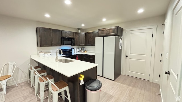 1794 N 1260 E, Payson, UT 84651 - kitchen featuring light countertops, a breakfast bar, a sink, dark brown cabinets, and black appliances