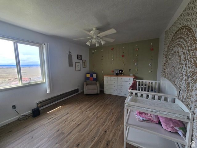 326 W 4800 S, Preston, ID 83263 - bedroom featuring a textured ceiling, a baseboard radiator, baseboards, wood finished floors, and a ceiling fan