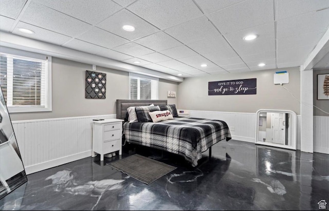 bedroom with a wainscoted wall, recessed lighting, and a drop ceiling