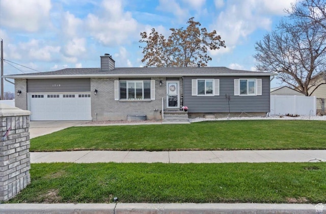 ranch-style home featuring fence, an attached garage, a chimney, concrete driveway, and a front yard